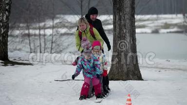 一家人在孩子摔倒的时候试图穿着大型滑雪板